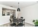 Bright dining area showcasing a modern pendant light, table with four chairs and kitchen with stainless steel appliances at 2433 Hideaway S Dr, Indianapolis, IN 46268