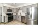 Well-lit kitchen featuring stainless steel appliances, gray cabinets, white countertop and backsplash at 2433 Hideaway S Dr, Indianapolis, IN 46268