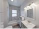 Well-lit bathroom featuring marble tile surround, modern vanity, and tub at 244 W 31St St, Indianapolis, IN 46208