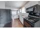 Well-lit kitchen features white cabinets, granite countertops, and modern black appliances at 244 W 31St St, Indianapolis, IN 46208