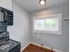 Bright kitchen area featuring wood floors, a window, and appliance connections, creating a functional space at 244 W 31St St, Indianapolis, IN 46208