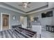 A modern bedroom with a tray ceiling, ceiling fan, dresser, and stylish furniture at 2502 Colinbrook Pkwy, Greenwood, IN 46143