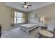 A bright bedroom featuring a bed, a nightstand with a lamp, and a sitting chair at 2502 Colinbrook Pkwy, Greenwood, IN 46143
