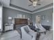 A modern bedroom with a tray ceiling, ceiling fan, dresser, and stylish furniture at 2502 Colinbrook Pkwy, Greenwood, IN 46143