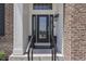 Stylish front door features glass paneling, black trim, and elegant outdoor lighting fixture at 2502 Colinbrook Pkwy, Greenwood, IN 46143