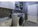 Well-equipped laundry room with modern washer and dryer, storage cabinets, and utility sink at 2502 Colinbrook Pkwy, Greenwood, IN 46143