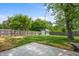 View of a fully fenced backyard featuring a patio, storage shed, and mature trees at 2537 N Boehning St, Indianapolis, IN 46219