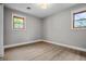 This empty bedroom has gray walls, a ceiling fan, and two windows at 2537 N Boehning St, Indianapolis, IN 46219