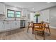 Kitchen with wood floors, white cabinets, stainless steel appliances, and a view of the dining area and outside at 2537 N Boehning St, Indianapolis, IN 46219