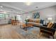 Open-concept living room featuring stylish furniture, wood floors, recessed lighting, and a view of the dining room and kitchen at 2537 N Boehning St, Indianapolis, IN 46219