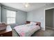 Cozy bedroom with a colorful comforter, soft carpeting, and a window that fills the space with natural light at 3010 Underwood Ct, Whiteland, IN 46184