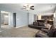 Open-concept living room with plush carpeting, ceiling fan, and modern furnishings flowing into the kitchen at 3010 Underwood Ct, Whiteland, IN 46184