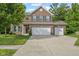 Charming two-story brick home with a three-car garage and manicured lawn at 3068 Reflection Ct, Greenwood, IN 46143