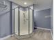 Bathroom featuring standing shower with glass door, light gray walls, and laminate flooring at 3714 Turfway Ct, Indianapolis, IN 46228