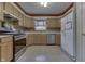 A well-lit kitchen featuring wooden cabinets, a stainless steel dishwasher, and a white refrigerator at 3714 Turfway Ct, Indianapolis, IN 46228