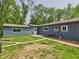 Fenced-in backyard with a well-maintained lawn, brick path, and mature trees creating a serene outdoor space at 4020 N Mitthoefer Rd, Indianapolis, IN 46235