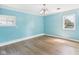 Bright, empty bedroom featuring light blue walls, white trim, and light hardwood floors at 4020 N Mitthoefer Rd, Indianapolis, IN 46235