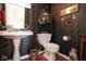Compact bathroom with pedestal sink, toilet, and decorative wallpaper at 4342 Sequoia Ct, Greenwood, IN 46143