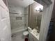 Bright bathroom featuring marble-style tiling, white fixtures and a shower-tub combination at 4402 E New York St, Indianapolis, IN 46201