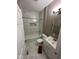 Bright bathroom featuring marble-style tiling, white fixtures and a shower-tub combination at 4402 E New York St, Indianapolis, IN 46201