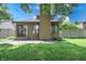 An exterior view of the rear of a home with a well-kept lawn, a cozy patio, and sliding glass doors at 4462 Carya Sq, Columbus, IN 47201