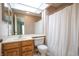 Bathroom featuring a wood vanity, a toilet, and tub with shower under a skylight at 4462 Carya Sq, Columbus, IN 47201