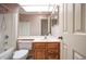 Bathroom featuring a tub with shower, wood vanity, and large mirror under a skylight at 4462 Carya Sq, Columbus, IN 47201