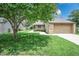 A well-maintained home with a one-car garage, lush green lawn, and mature shade tree at 4462 Carya Sq, Columbus, IN 47201