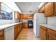 Functional kitchen featuring wood cabinets, white appliances, and ample counter space at 4462 Carya Sq, Columbus, IN 47201