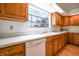 Traditional kitchen with light wood cabinets, white countertops, and a window overlooking the yard at 4462 Carya Sq, Columbus, IN 47201