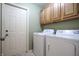 Laundry room featuring a washer, dryer, and cabinets for storage space at 4462 Carya Sq, Columbus, IN 47201
