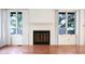 Living room with hardwood floors and fireplace, illuminated by large windows at 4462 Carya Sq, Columbus, IN 47201