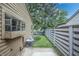 An exterior shot displaying the side yard, featuring a concrete area, fencing, and mature trees at 4462 Carya Sq, Columbus, IN 47201