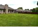 View of a large green backyard featuring a dark brown fence and partial view of the house at 4723 Goldenrain Ct, Indianapolis, IN 46237
