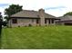 Spacious backyard with lush green grass, fenced in on one side with a brick chimney feature at 4723 Goldenrain Ct, Indianapolis, IN 46237
