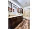 Well-lit bathroom featuring double sinks, a shower-tub combo, and stylish wood-look flooring at 4723 Goldenrain Ct, Indianapolis, IN 46237
