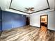 A luxurious main bedroom features a ceiling fan, wood floors and a view to the bathroom at 4723 Goldenrain Ct, Indianapolis, IN 46237