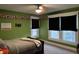 Bedroom with green walls, natural light, and large windows with privacy shades at 48 N Audubon Rd, Indianapolis, IN 46219