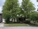 Traditional two-story home partially obscured by mature trees; features a welcoming covered porch at 48 N Audubon Rd, Indianapolis, IN 46219