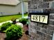 Close-up of house number on brick exterior, with greenery and flowers in the background creating a welcoming scene at 4817 Allium Dr, Plainfield, IN 46168