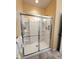 Clean shower enclosure with sliding glass doors and a built-in shower seat at 4817 Allium Dr, Plainfield, IN 46168