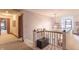 Upstairs hallway with carpeted floors, a black storage bench, and elegant chandelier lighting at 505 Jones Pl, Martinsville, IN 46151
