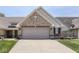 Exterior view of home with brick facade, well-manicured lawn, and a two-car garage at 5351 Abbington Ave, Plainfield, IN 46168