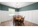 Charming dining room featuring wainscoting, a modern chandelier, and a cozy table set with flowers at 5625 Winston Dr, Indianapolis, IN 46226
