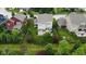Aerial view showcasing the backyard, including a deck, patio, fire pit, and mature trees at 5684 Autumn Trl, Brownsburg, IN 46112