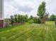 Well-maintained backyard featuring a defined lawn, privacy trees and landscape features at 5684 Autumn Trl, Brownsburg, IN 46112