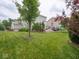 Lush backyard with mature trees and manicured lawn, with patio and outdoor seating visible at 5684 Autumn Trl, Brownsburg, IN 46112