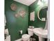Charming powder room featuring green walls and decorative wall art at 5684 Autumn Trl, Brownsburg, IN 46112