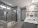 Neutral bathroom with gray tile, glass enclosed shower, and double sink vanity at 5684 Autumn Trl, Brownsburg, IN 46112