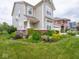 Landscaped front yard featuring a variety of colorful plants and a lush green lawn at 5684 Autumn Trl, Brownsburg, IN 46112
